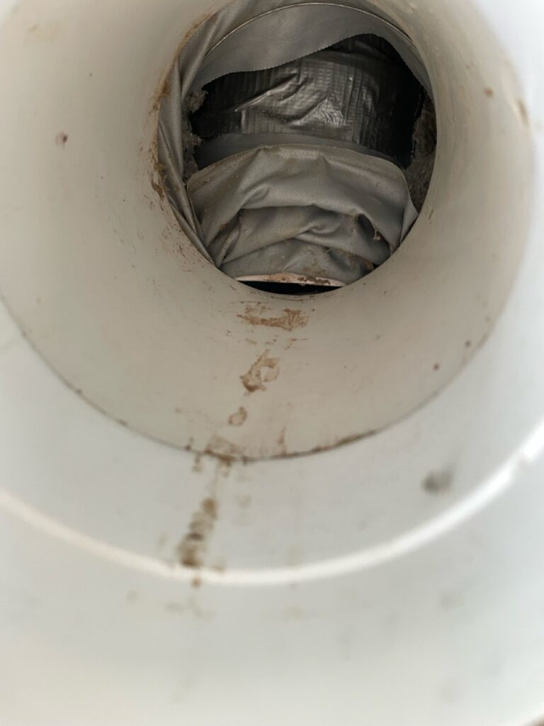 Looking up into an MVHR terminal. The duct connection has been crushed and almost completely blocks the passage of air.